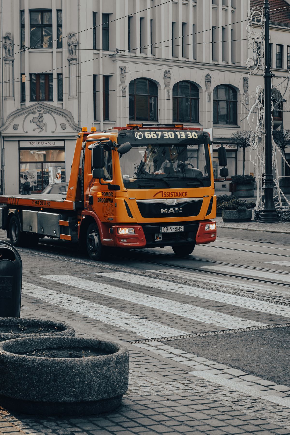 Camion de remorquage orange dans une rue urbaine